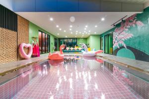 a swimming pool with pink inflatable swans in the middle at Le Villa Huahin in Ban Khao Rang