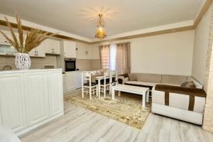 een keuken en woonkamer met een tafel en een bank bij LuxuryHomeUlcinj in Ulcinj