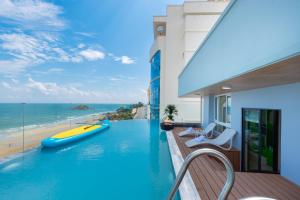 une piscine avec une planche de surf sur le toit d'un bâtiment dans l'établissement ONE SEASON BOUTIQUE HOTEL Vung Tau - BEACHFRONT, à Vung Tau