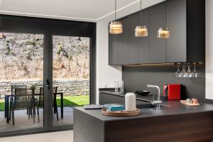 a kitchen with black cabinets and a counter with a table at Panorama Royale Penthouse in Bellinzona +13 photos
