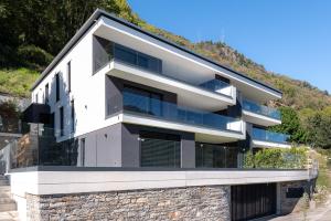 una casa en una colina con ventanas de vidrio en Terrace, Garden & Castle View, en Bellinzona