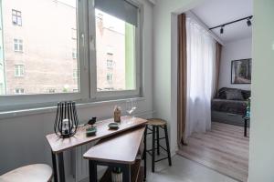 a living room with a table and a window at Apartly - City Home &B in Szczecin +8 photos