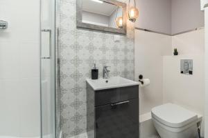 a bathroom with a toilet and a sink and a shower at Apartly - City Home &B in Szczecin
