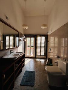 a bathroom with a sink and a toilet and a tub at Emerald Tiger Retreat in Tāla