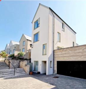 ein weißes Gebäude mit einer Garage davor in der Unterkunft Coastal Oasis - Large Family Home in Portland