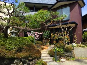 a house with a tree in front of it at Hananobou Kinkakuji-michi in Kyoto