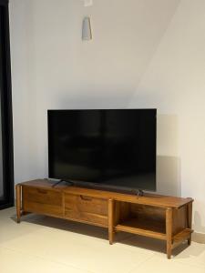a flat screen tv sitting on top of a wooden entertainment center at Ozone The Misty Villa - Hill View in Coonoor +10 photos