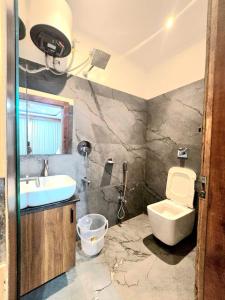 a bathroom with a sink and a toilet and a shower at Pratima Heritage in Bhubaneshwar