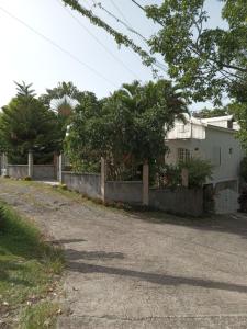 a house with a fence next to a road at La Plus Grande Source D'eaux Chaudes " Guadeloupe " in Bouillante