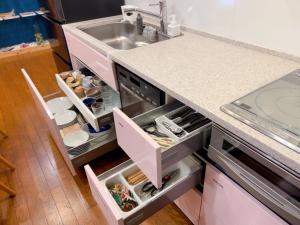 eine Küche mit Spüle und offenem Kühlschrank in der Unterkunft ゲストハウス ブランク Guest House BLANC in Hiroshima