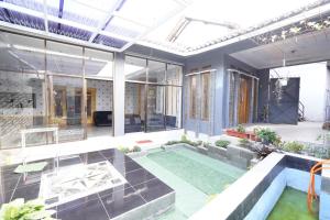 a house with a swimming pool and a patio at Hotel O 94911 Syariah Anggrek Guest House in Lebakwangi