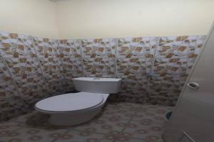 a bathroom with a white toilet in a room at Hotel O 94911 Syariah Anggrek Guest House in Lebakwangi +25 photos