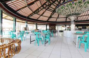 a restaurant with blue chairs and tables and a large ceiling at OYO 94936 Pondok Purnama in Ciwidey