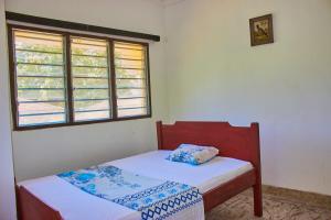 a small bedroom with a bed and two windows at MK Casa Modern 3BR Retreat Fully Furnished in Malindi