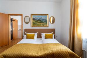 ein Schlafzimmer mit einem großen Bett mit gelben Kissen in der Unterkunft Höllental heritage house - Zugspitzblick - 3 in Garmisch-Partenkirchen