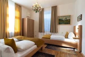 ein Schlafzimmer mit zwei Betten und einem Kronleuchter in der Unterkunft Höllental heritage house - Zugspitzblick - 3 in Garmisch-Partenkirchen