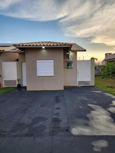 uma casa com duas portas brancas de garagem numa garagem em Comfortable house in a gated community em Rondonópolis mais 15 fotografias