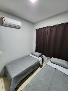 um quarto com 2 camas individuais e uma janela em Comfortable house in a gated community em Rondonópolis