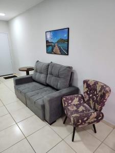 uma sala de estar com um sofá e uma cadeira em Comfortable house in a gated community em Rondonópolis