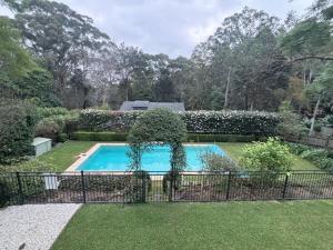 a swimming pool in a yard with a fence at Self-contained unit in Wahroonga in Warrawee