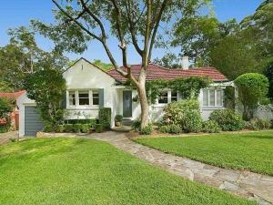 a white house with a tree in a yard at Self-contained unit in Wahroonga in Warrawee