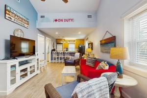 a living room with a red couch and a tv at Neptunes Palace A1 in Saint George Island