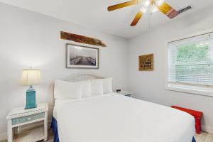 a bedroom with a white bed and a ceiling fan at Neptunes Palace A1 in Saint George Island +19 photos