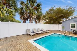 a swimming pool with chairs and a white fence at Neptunes Palace A1 in Saint George Island