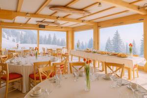 a dining room with tables and chairs with snow at Hotel Krvavec in Cerklje na Gorenjskem