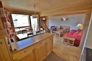 a kitchen and living room with a red couch at Refuge Les Echelles E4 in Le Grand-Bornand