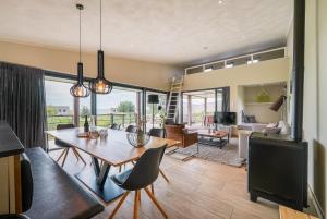 a living room with a table and chairs at Exclusive Duin Villa - 6p - Direct bij Natuur & Strand - Villa 70 in Ouddorp