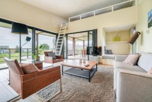 ein Wohnzimmer mit Sofa und Tisch in der Unterkunft Exclusive Duin Villa - 6p - Direct bij Natuur & Strand - Villa 70 in Ouddorp