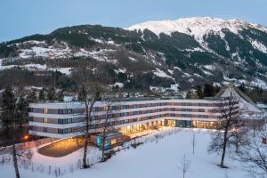 a building in the snow in front of a mountain at TUI BLUE Montafon in Schruns