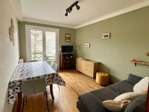 a living room with a table and a couch at La Petite Ourse maison de village à Oust in Oust