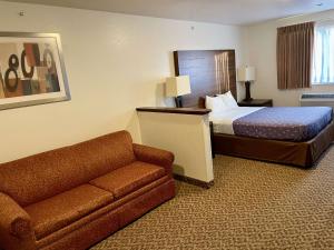 a hotel room with a bed and a couch at SureStay by Best Western Prince Frederick in Prince Frederick