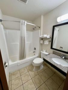 a bathroom with a toilet and a tub and a sink at SureStay by Best Western Prince Frederick in Prince Frederick