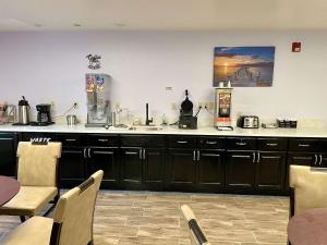 a kitchen with black cabinets and a table and chairs at SureStay by Best Western Prince Frederick in Prince Frederick