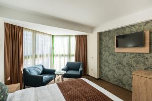 Habitación de hotel con 1 cama, 2 sillas y TV en Hotel Somi Inn, en Tiflis