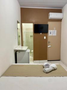 a room with a bed with a sink and a mirror at POUSADA AREIAS DE PAJUÇARA in Maceió