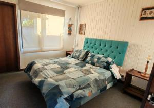 une chambre avec un lit bleu et une fenêtre dans l'établissement Hostal Punto Rockstar, à Osorno