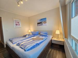 ein Schlafzimmer mit einem großen Bett mit blauer Bettwäsche in der Unterkunft Ferienwohnung Norddeichurlaub in Norddeich