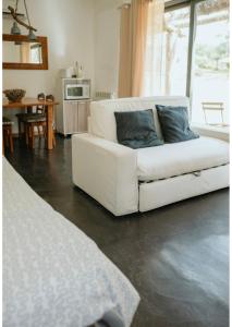 a white couch with two blue pillows in a living room at Monte das Mariolas in Castelo de Vide