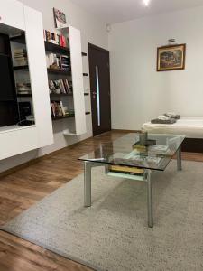 a living room with a glass table and a book shelf at Modern Apartment in the Heart of Vidin in Vidin +2 photos