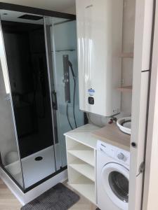 a bathroom with a shower and a washing machine at Le refuge sablais in Les Sables-dʼOlonne