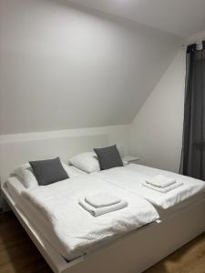 a white bed with two pillows on it at Gasthof Wilhelm Tell bei Anna in Zirndorf