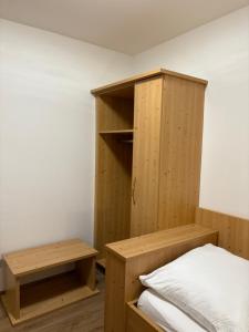 a bedroom with a wooden cabinet and a bed at Gasthof Wilhelm Tell bei Anna in Zirndorf