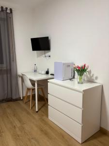 a white dresser with a desk with a microwave and a table at Gasthof Wilhelm Tell bei Anna in Zirndorf