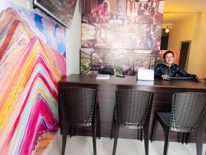 una donna seduta a un tavolo con un computer portatile di HOSTAl CUSCO-ECOTERRA a Cuzco