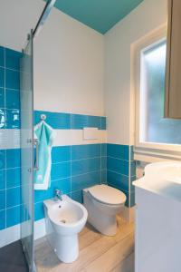 a blue and white bathroom with a toilet and a sink at Appartamento Pino Fetovaia by ElbaSummer Tour Operator in Fetovaia +10 photos