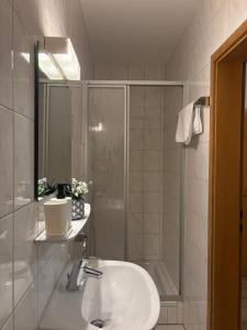 a bathroom with a sink and a shower at Gasthof Wilhelm Tell bei Anna in Zirndorf
